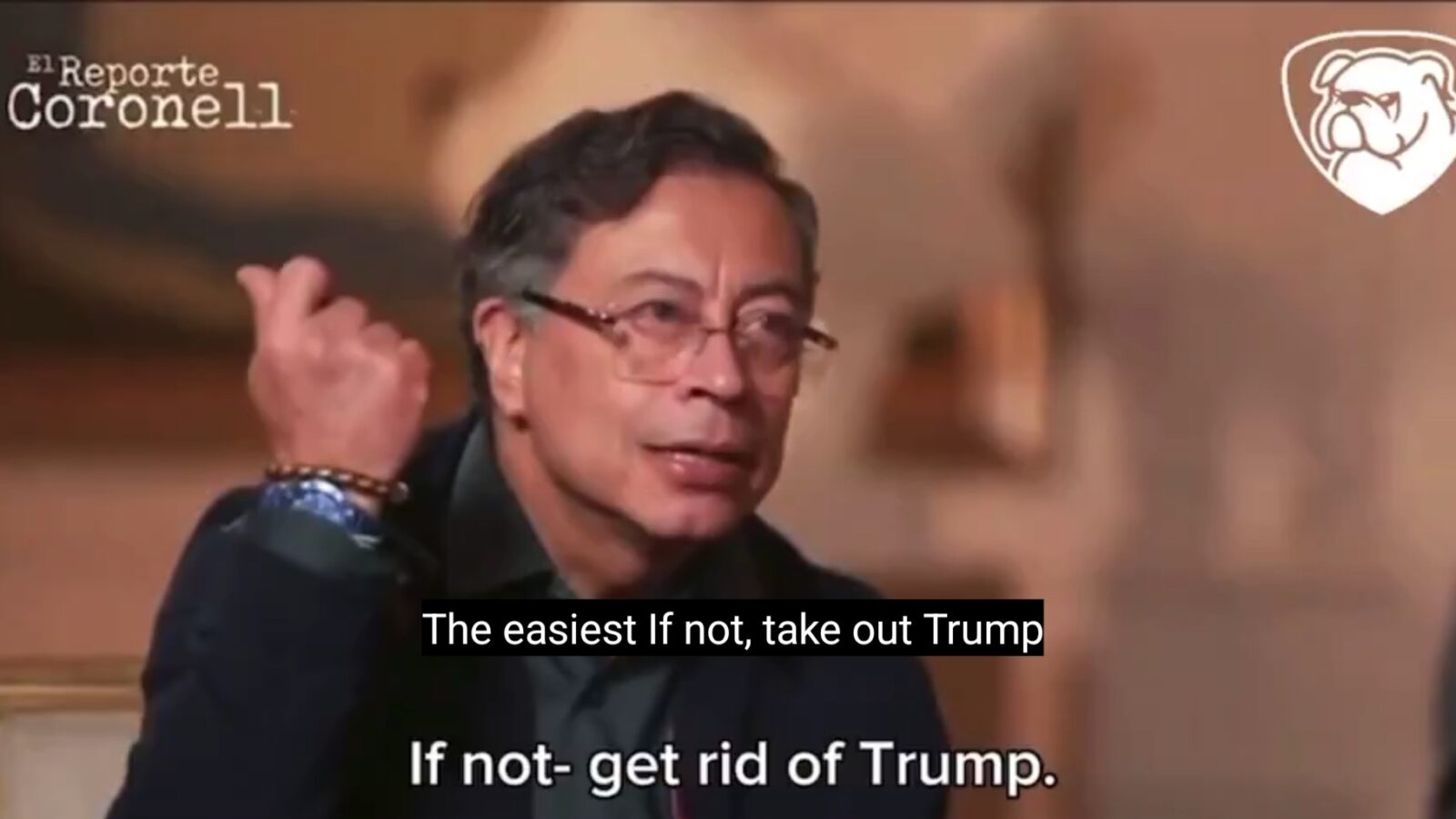 Interview segment featuring a speaker discussing political strategies, with emphasis on actions related to Trump, shown in a blurred background setting.