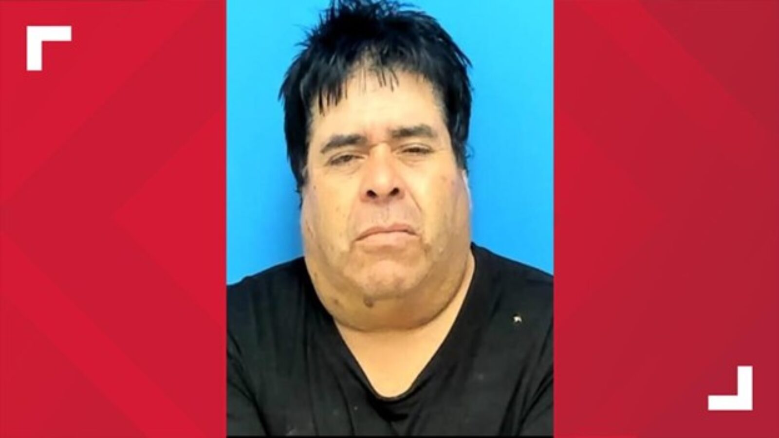 Mugshot of a middle-aged man with dark hair and a serious expression against a blue background.