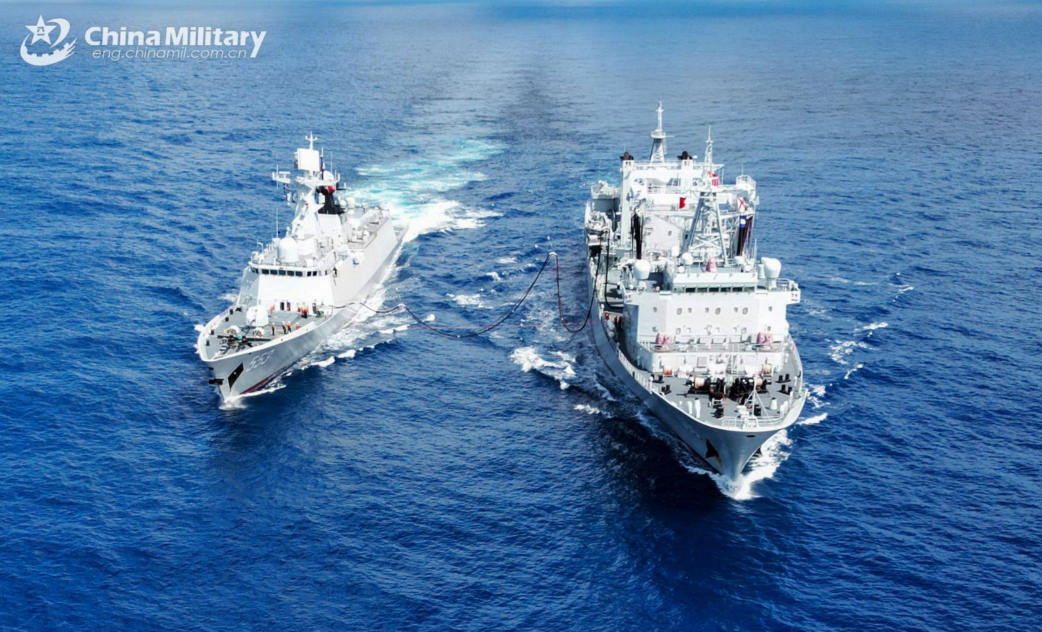 Two Chinese naval ships conducting a replenishment operation at sea, showcasing military capabilities and maritime collaboration in open waters.