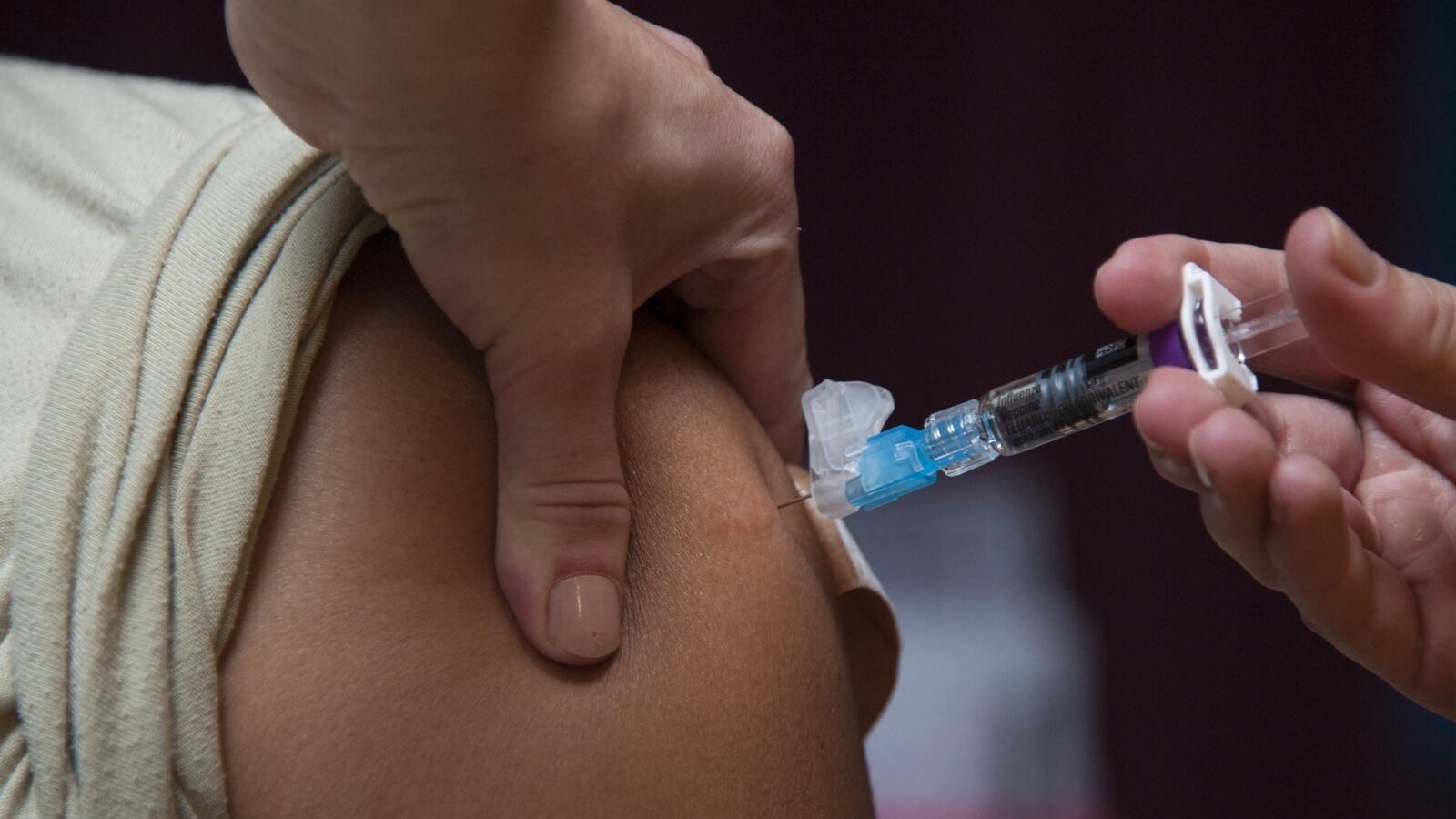 A healthcare professional administering a vaccine injection into a patient's upper arm, emphasizing the importance of immunization for health.