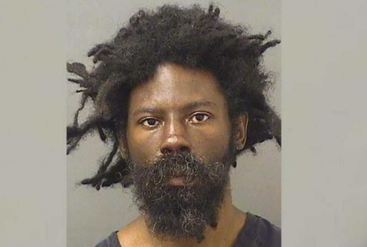 Mugshot of a man with long, unkempt hair and a beard, looking directly at the camera against a neutral background.