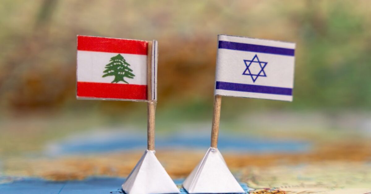 Miniature flags of Lebanon and Israel on a map, symbolizing the geopolitical relationship between the two countries.