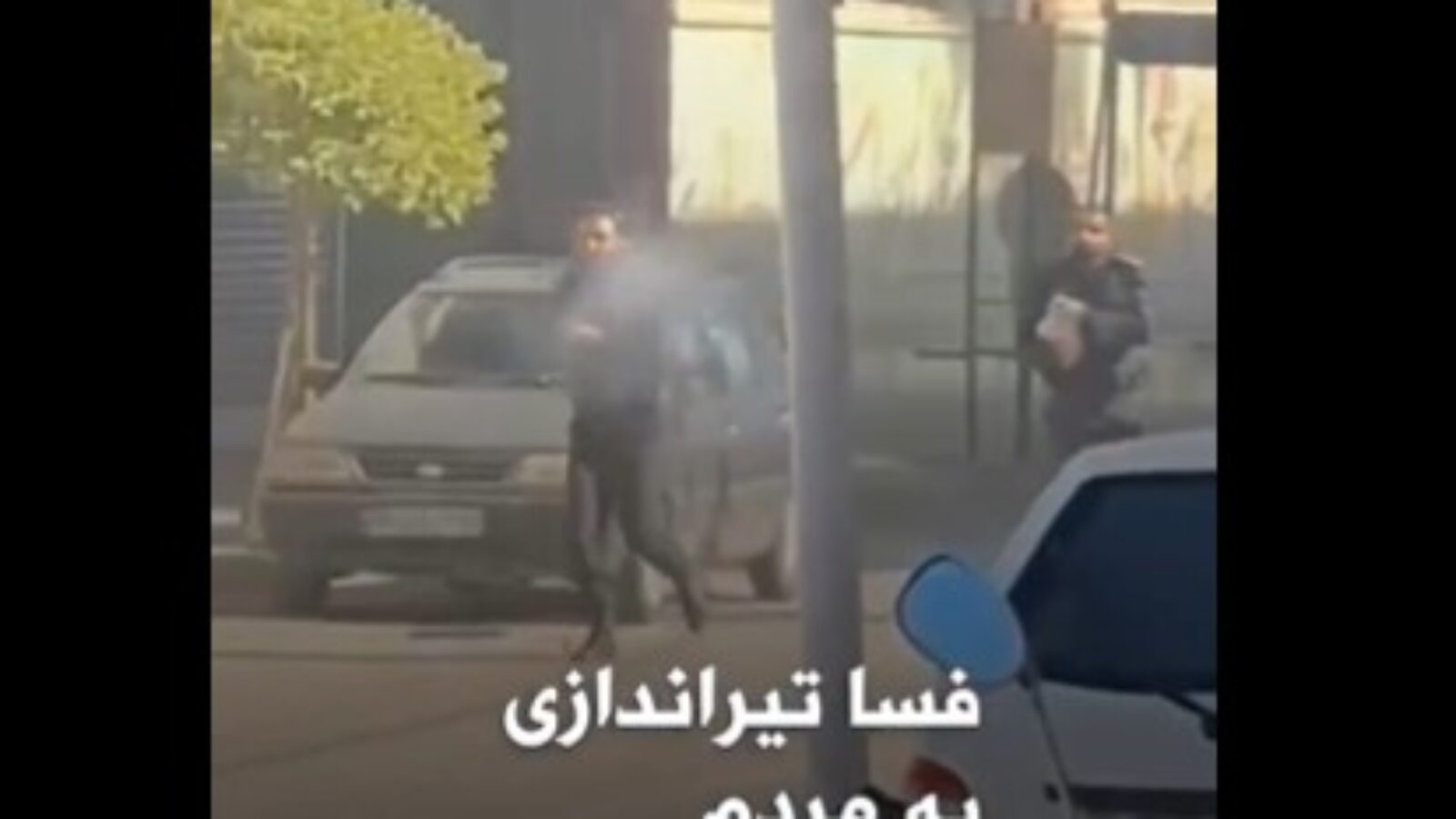 Police officers using tear gas during a crowd control situation in an urban setting.