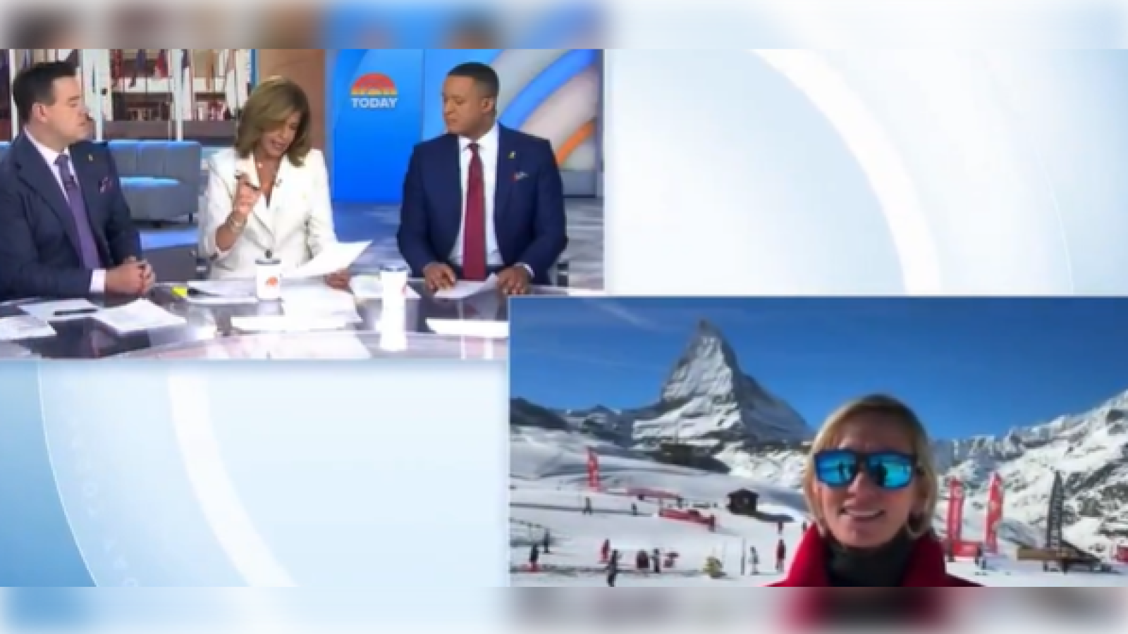 Television hosts discussing a winter sports event with a snowy mountain backdrop featuring a smiling guest wearing sunglasses.