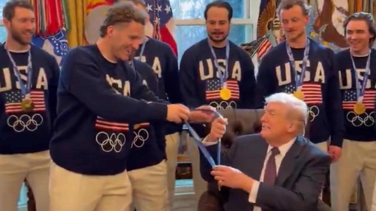 U.S. Olympic athletes present a medal to Donald Trump in a formal setting, showcasing team spirit and national pride.