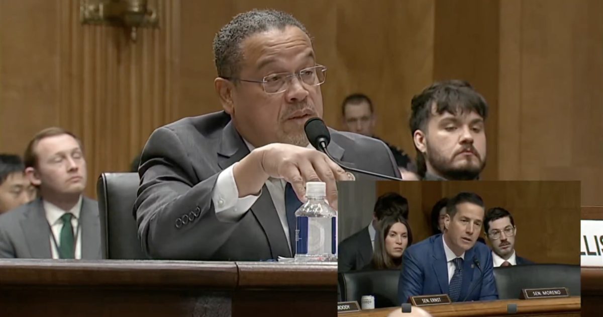A congressional hearing with a speaker addressing the committee, while other attendees listen attentively in the background.