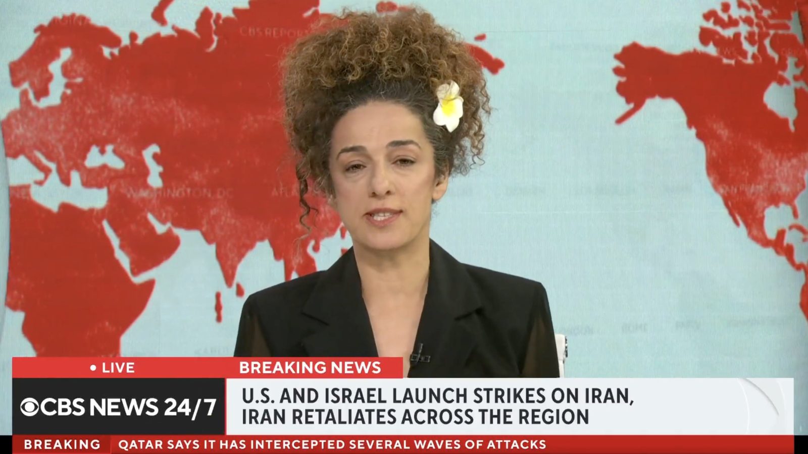News anchor reporting on breaking news regarding U.S. and Israel strikes on Iran, with a world map background highlighting the region.