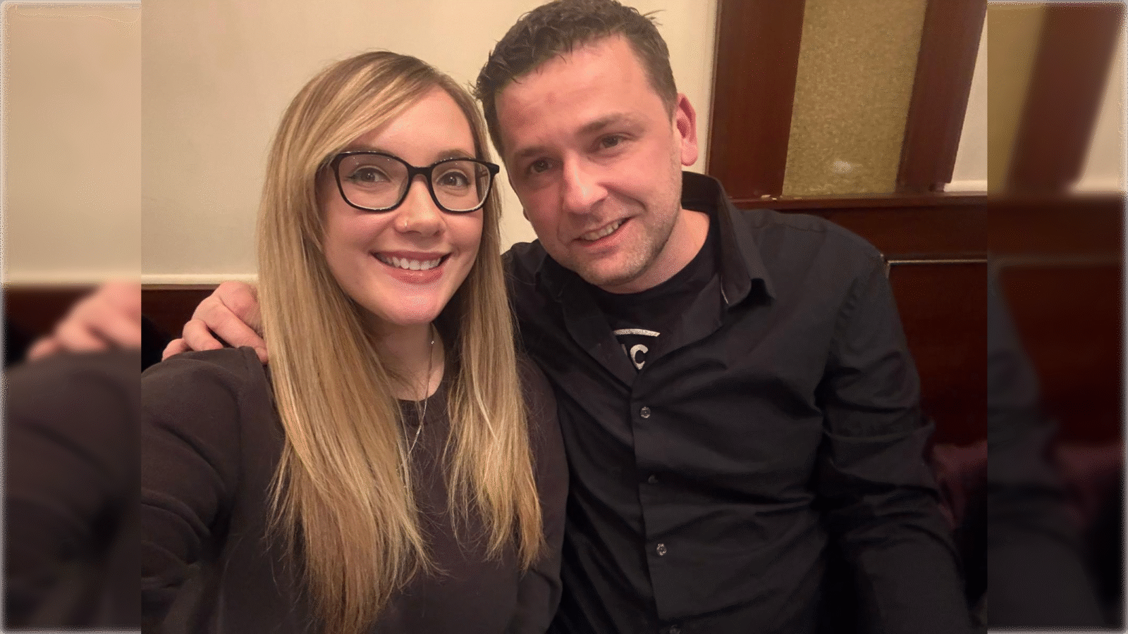 Smiling couple poses for a selfie in a cozy restaurant setting, showcasing a warm and friendly atmosphere.