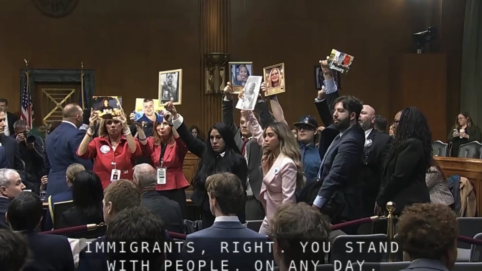 Activists hold photographs during a protest at a Senate hearing, advocating for immigrant rights and raising awareness about their personal stories.