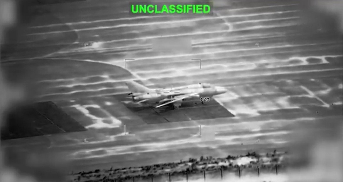 Aerial view of an unclassified military aircraft on a runway, captured in black and white thermal imaging.