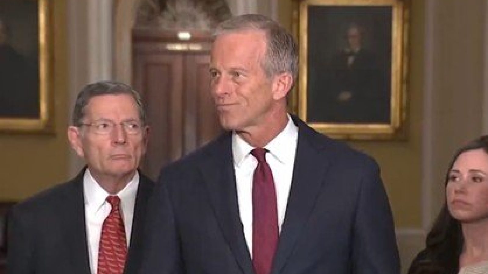 Senators John Thune and John Barrasso stand during a press conference in the U.S. Capitol, discussing key legislative issues with a serious demeanor.
