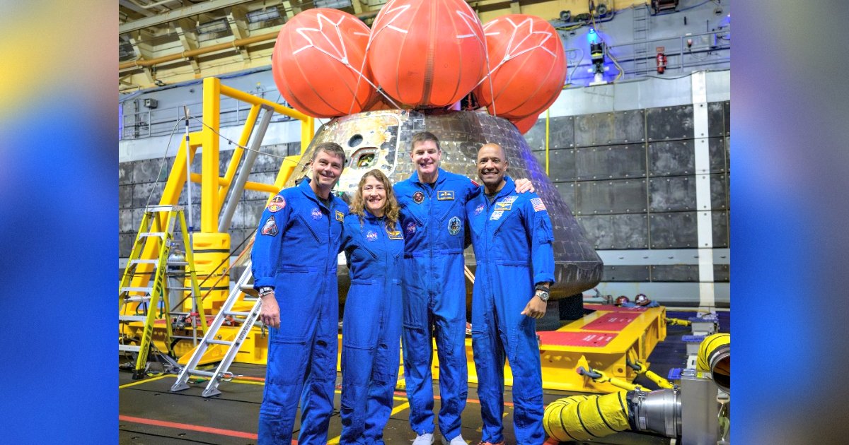 Four astronauts in blue flight suits pose in front of a spacecraft with a distinctive capsule design, showcasing advancements in space exploration technology.