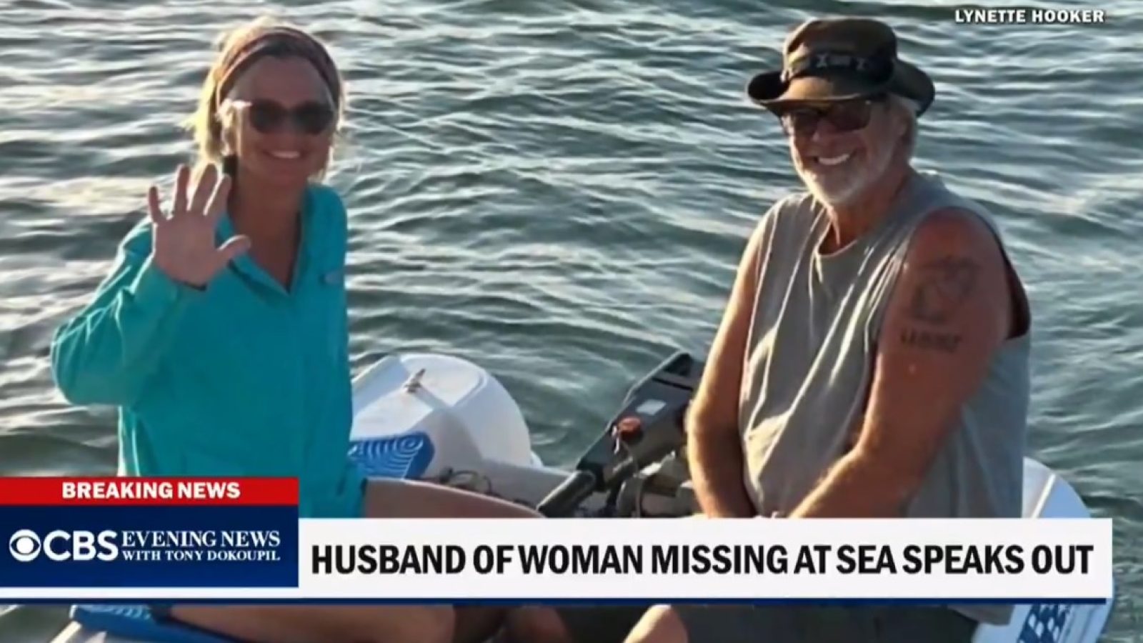 Husband and wife on a small boat, smiling and waving, during a news segment about a woman reported missing at sea.
