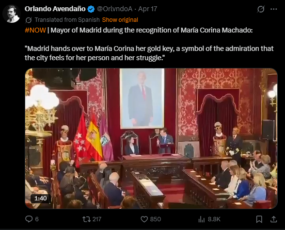 Mayor of Madrid presenting the gold key to María Corina Machado in a ceremonial event, symbolizing admiration for her contributions and struggles.