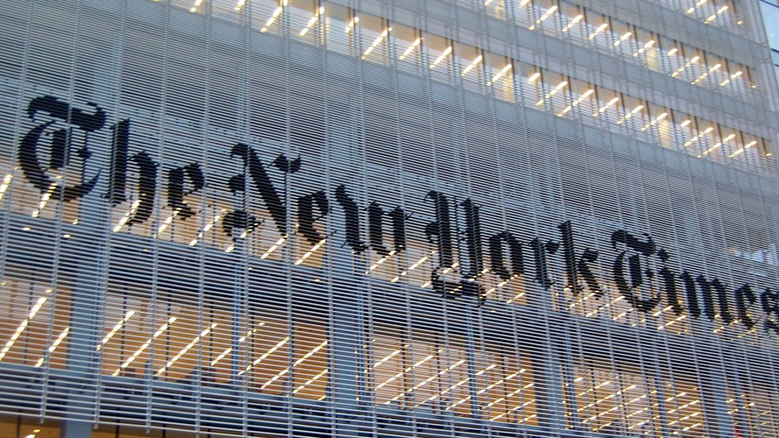 The New York Times logo displayed prominently on the building facade, showcasing modern architectural design and urban journalism.