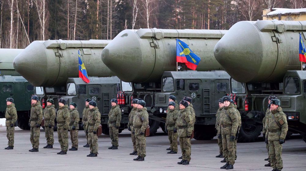 Military personnel stand in formation beside missile launchers, showcasing military readiness and equipment during a formal event.