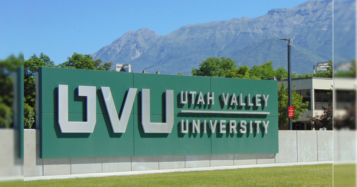 Signage for Utah Valley University with mountains in the background, showcasing the university's name and logo in a vibrant outdoor setting.