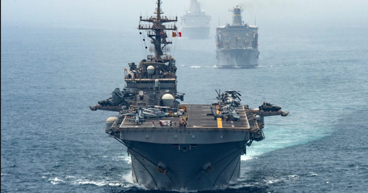 Naval vessels maneuver through calm waters, showcasing military ships with helicopters on deck during a maritime operation.