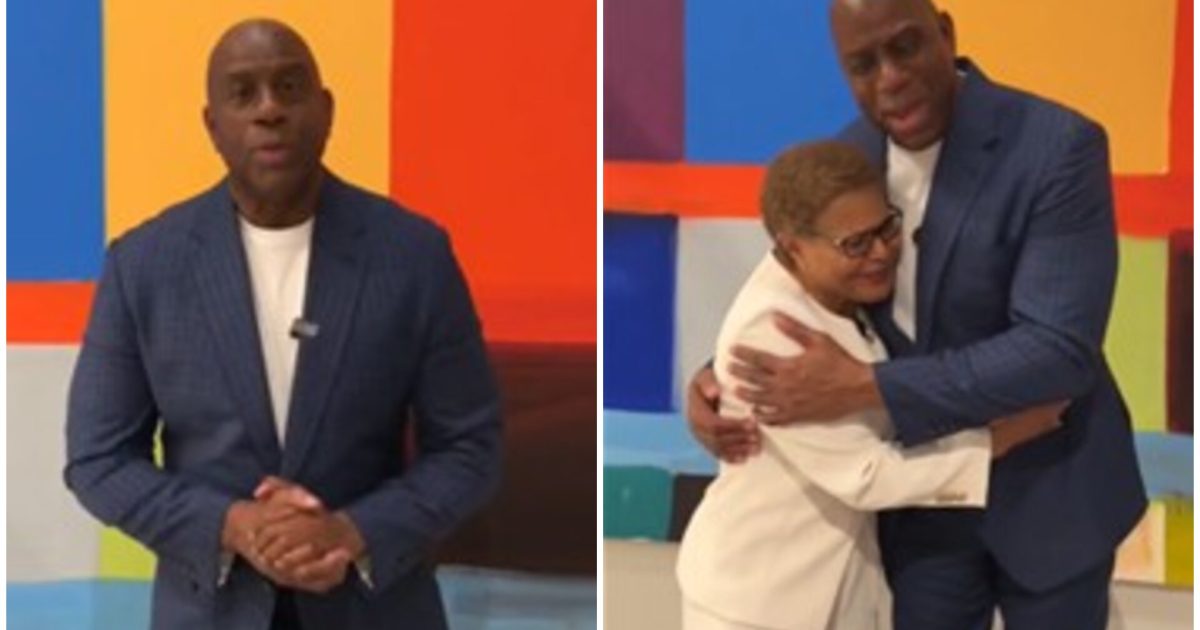 Magic Johnson stands in front of a colorful backdrop, engaging with a woman in a white outfit as they share a warm embrace.