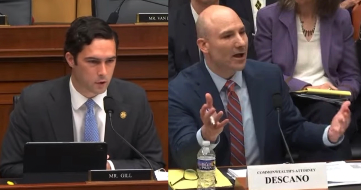 Two men engaged in a heated discussion during a congressional hearing, with one speaking passionately while the other listens intently.