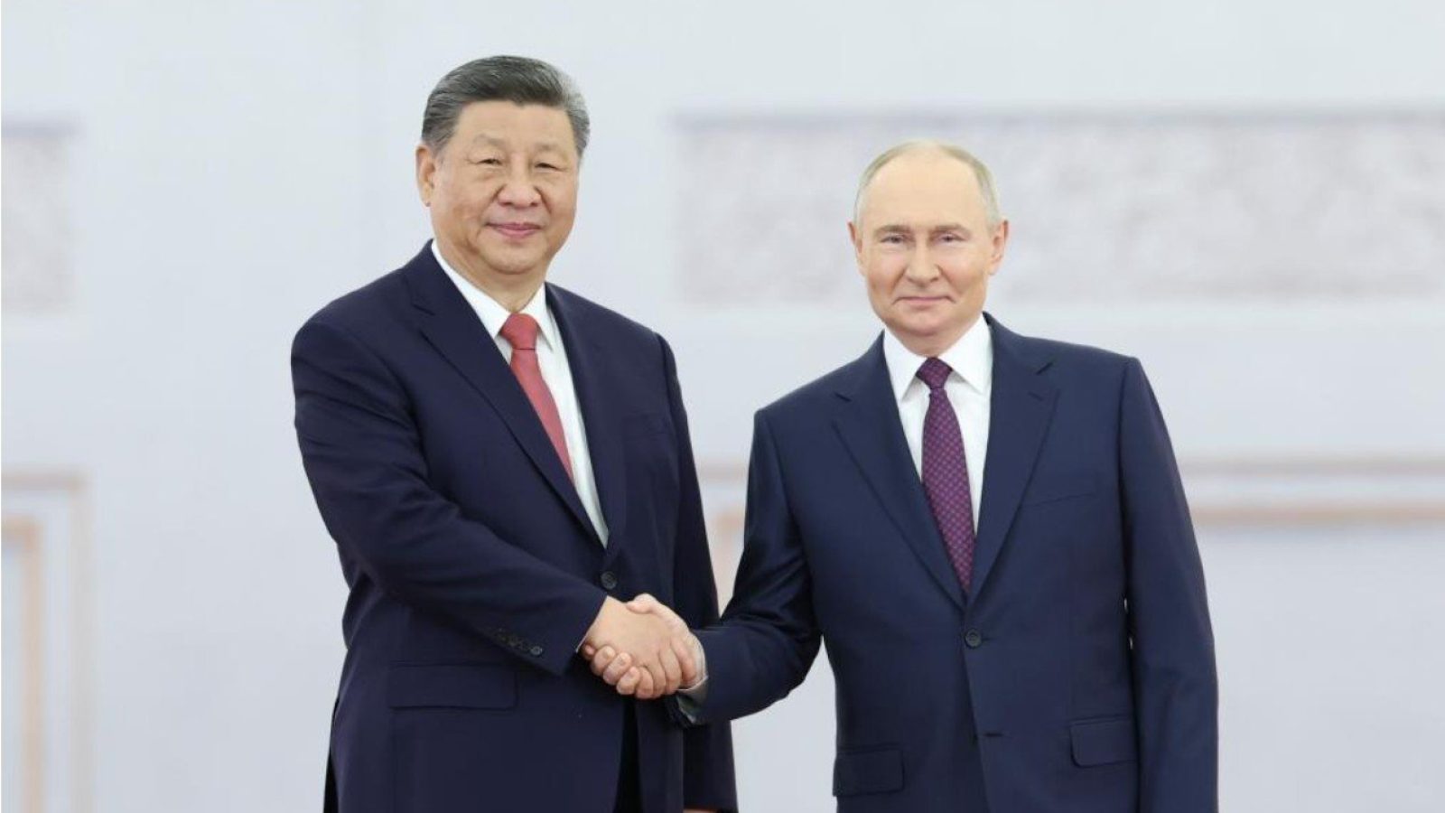 Chinese President Xi Jinping and Russian President Vladimir Putin shake hands at a formal meeting, symbolizing diplomatic relations between China and Russia.
