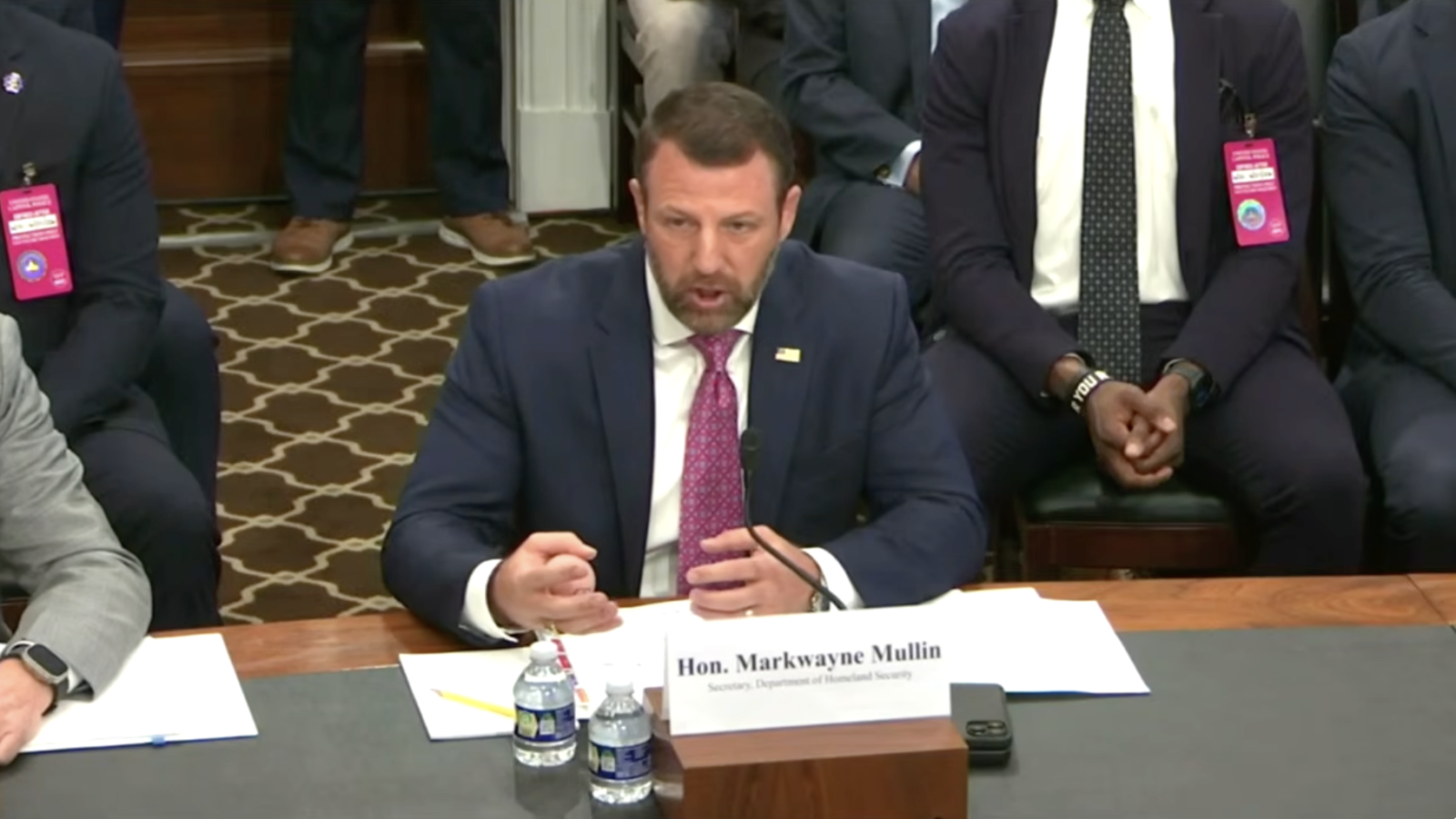 Markwayne Mullin, Secretary of Homeland Security, speaks during a congressional hearing, emphasizing key issues with fellow officials seated nearby.