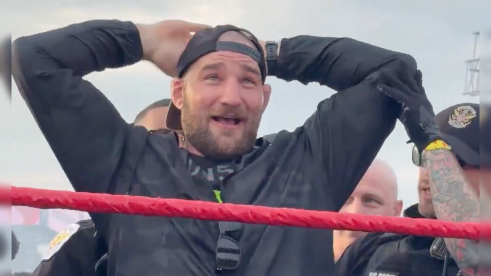 Excited man in a wrestling ring celebrating with friends, showcasing a lively atmosphere at a wrestling event.