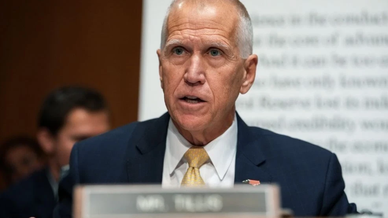 U.S. Senator speaking during a committee hearing with a serious expression, focused on important legislative issues.