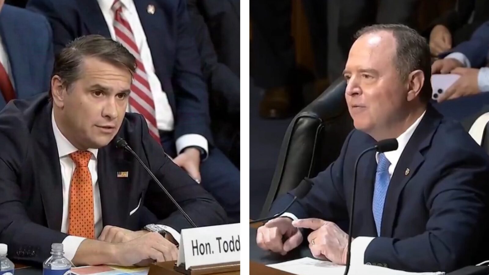 Two men engaged in a formal discussion during a congressional hearing, with one speaking into a microphone and the other listening attentively.
