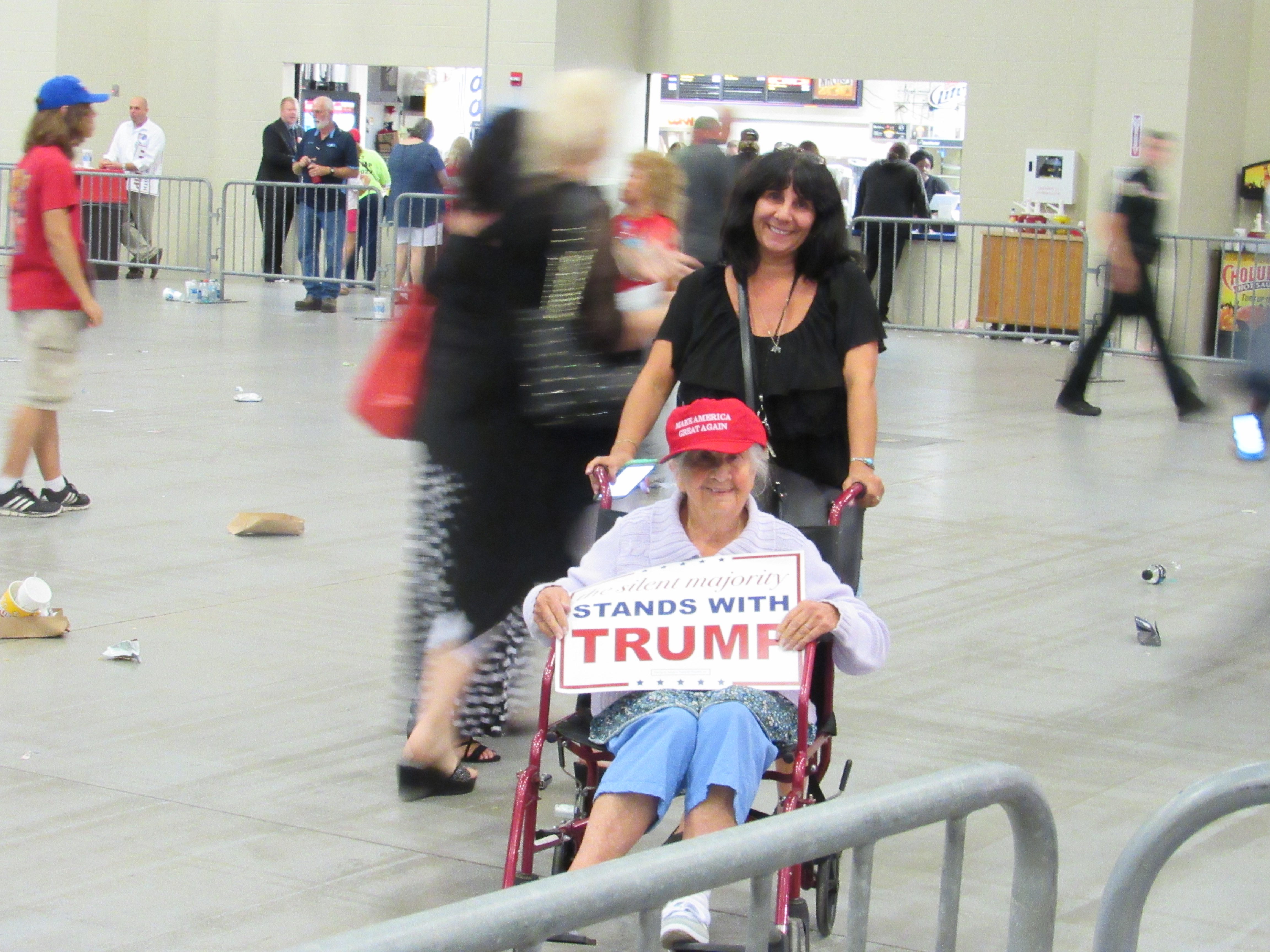 Elderly woman holds Trump sign for media after West Palm Beach rally