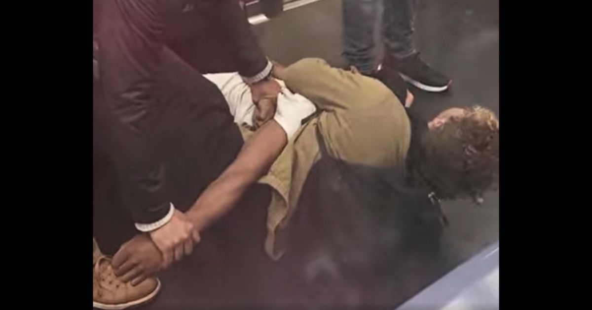 A homeless, mentally disturbed man is restrained by subway passengers in New York City.