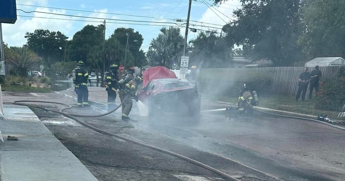 firefighters working to extinguish the flames in a burning Tesla